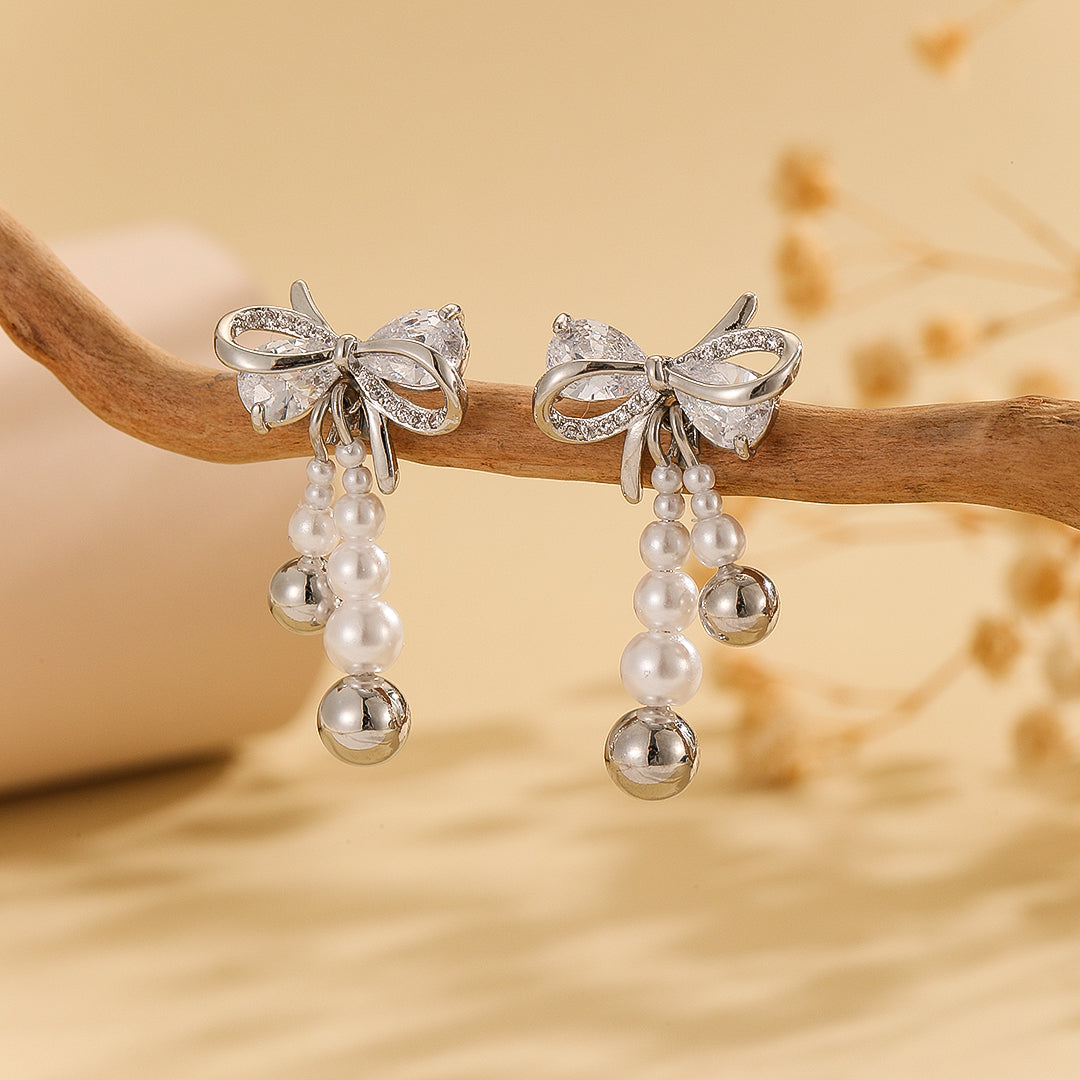 “Pearlescent Silver Bow Earrings - Reet Pehal