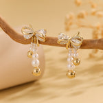 Load image into Gallery viewer, Pearlescent Golden Bow Earrings - Reet Pehal
